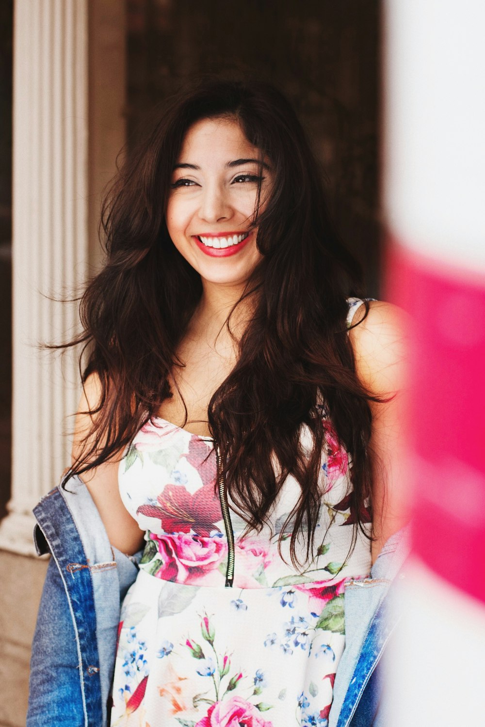 woman wears floral dress smile inside room