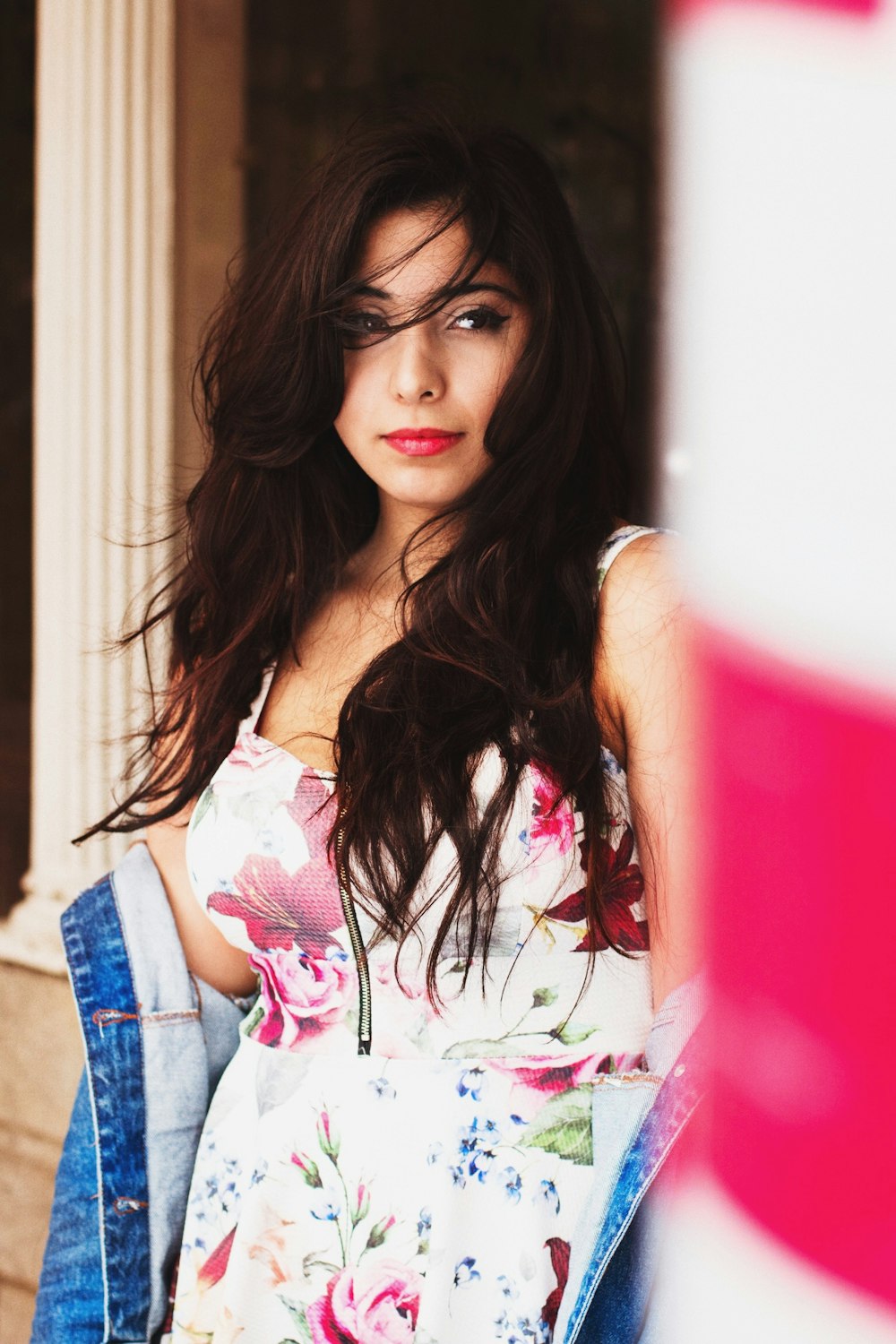 shallow focus photography of woman in white, green, and red floral spaghetti strap top