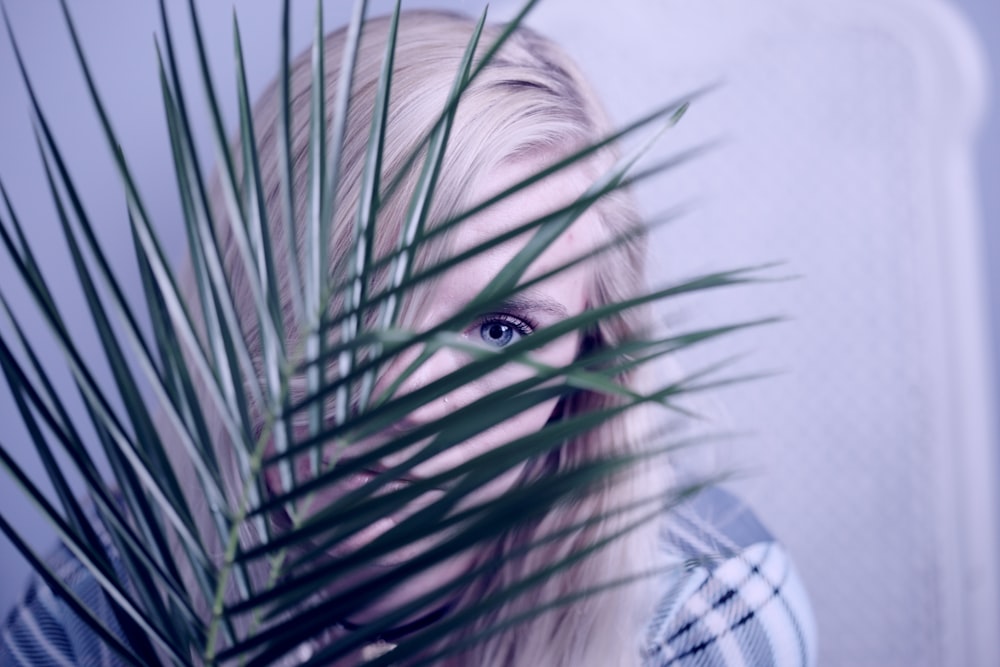 woman covering face with leaves