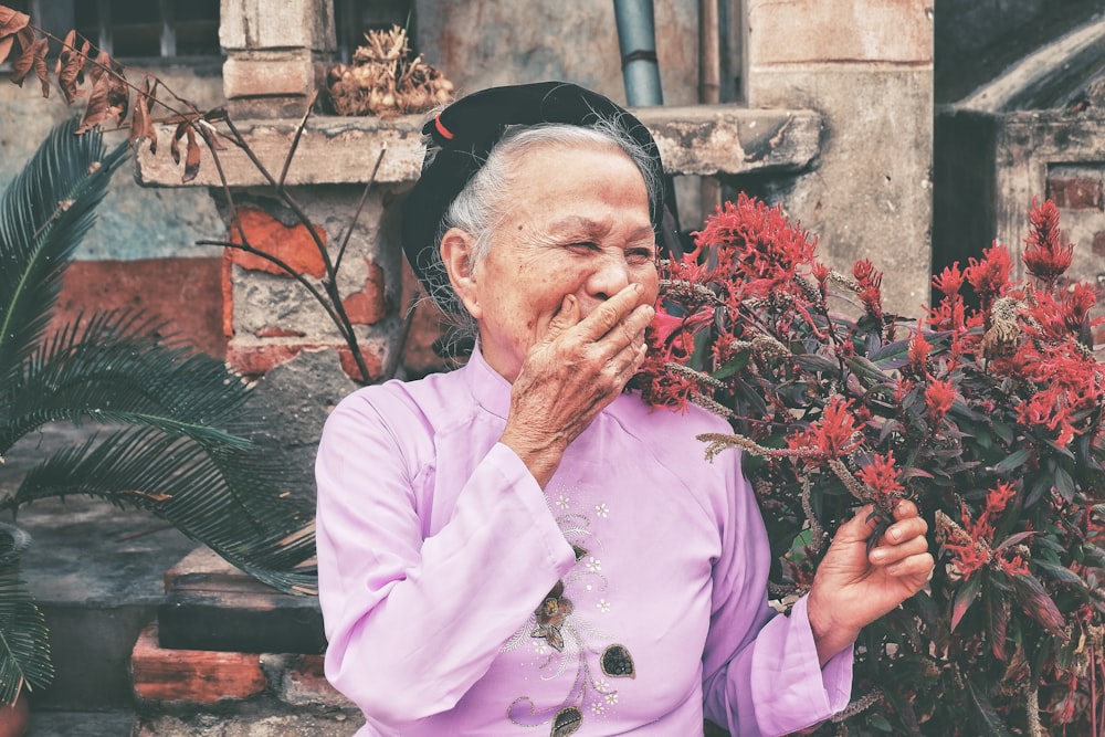 woman holding red petaled flowers