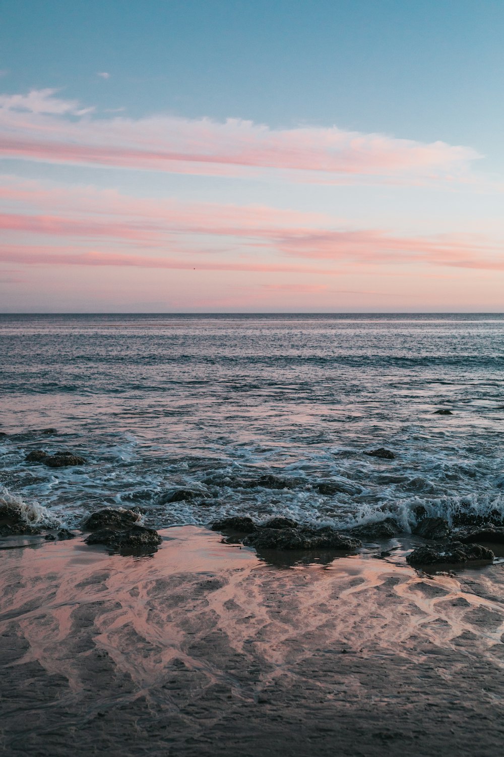 body of water with pink sky