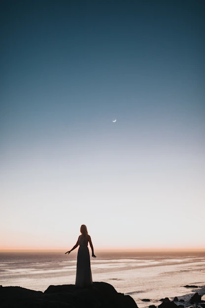 A contemplative man standing on a rugged coastline at dusk, symbolizing resilience and new beginnings.