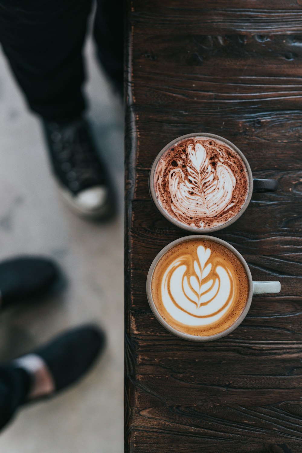 tasses grises et noires remplies de café sur la table