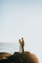woman and man standing on brown rock formation during daytime