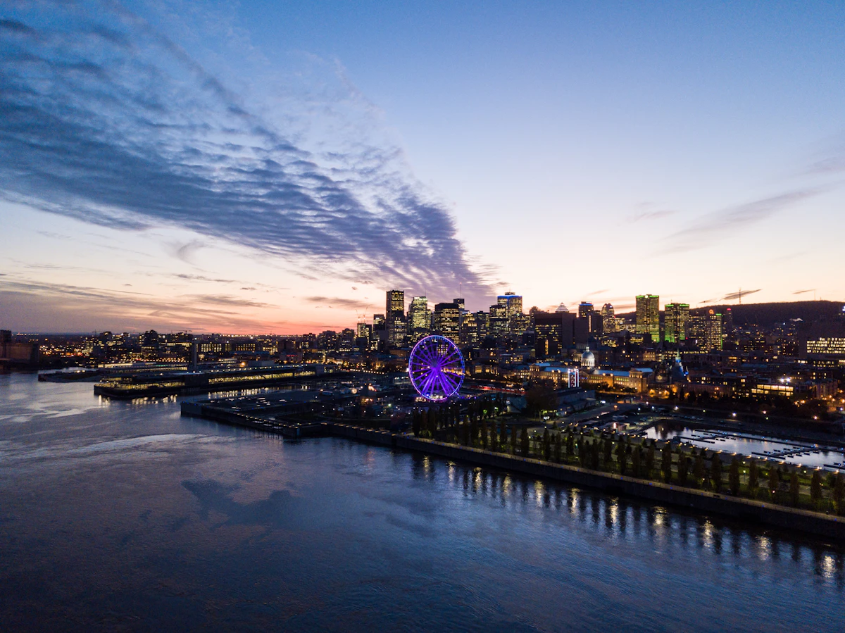 Montréal's illuminated skyline, river and Old Port seen at blue hour