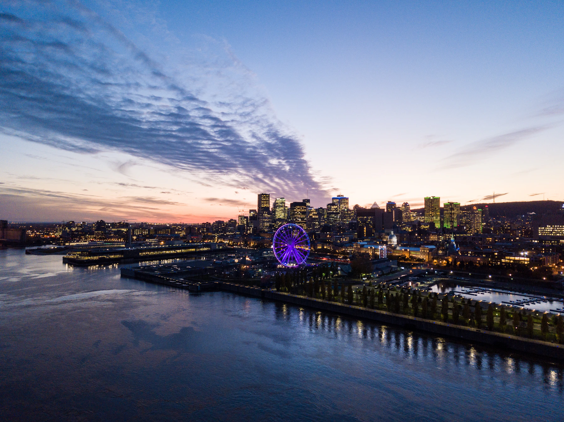 Montréal's illuminated skyline, river and Old Port seen at blue hour