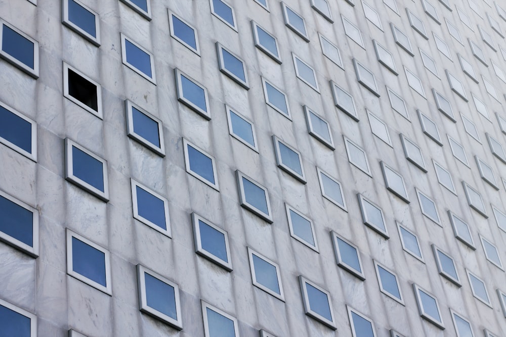 photo of gray concrete building with clear glass windows at daytime