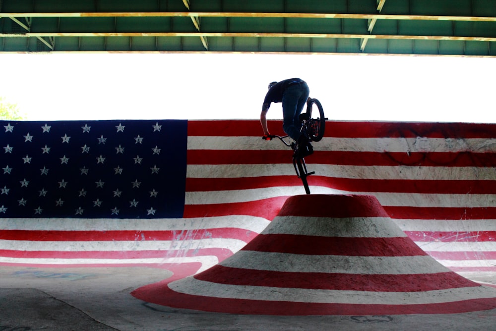 man riding bike performing stunts on ramp during daytime