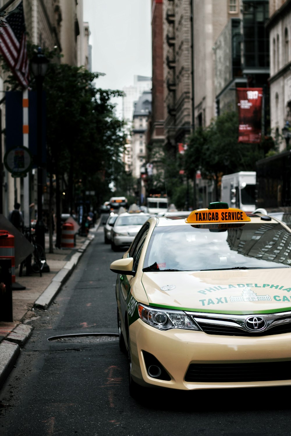 Taxi bianco sulla strada asfaltata grigia durante il giorno