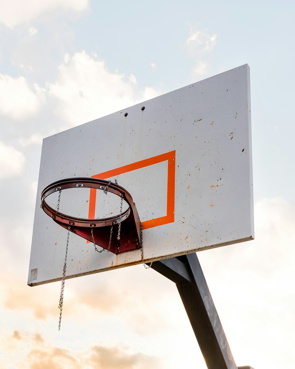 Canestro da basket in acciaio arancione montato su bordo da basket in legno bianco
