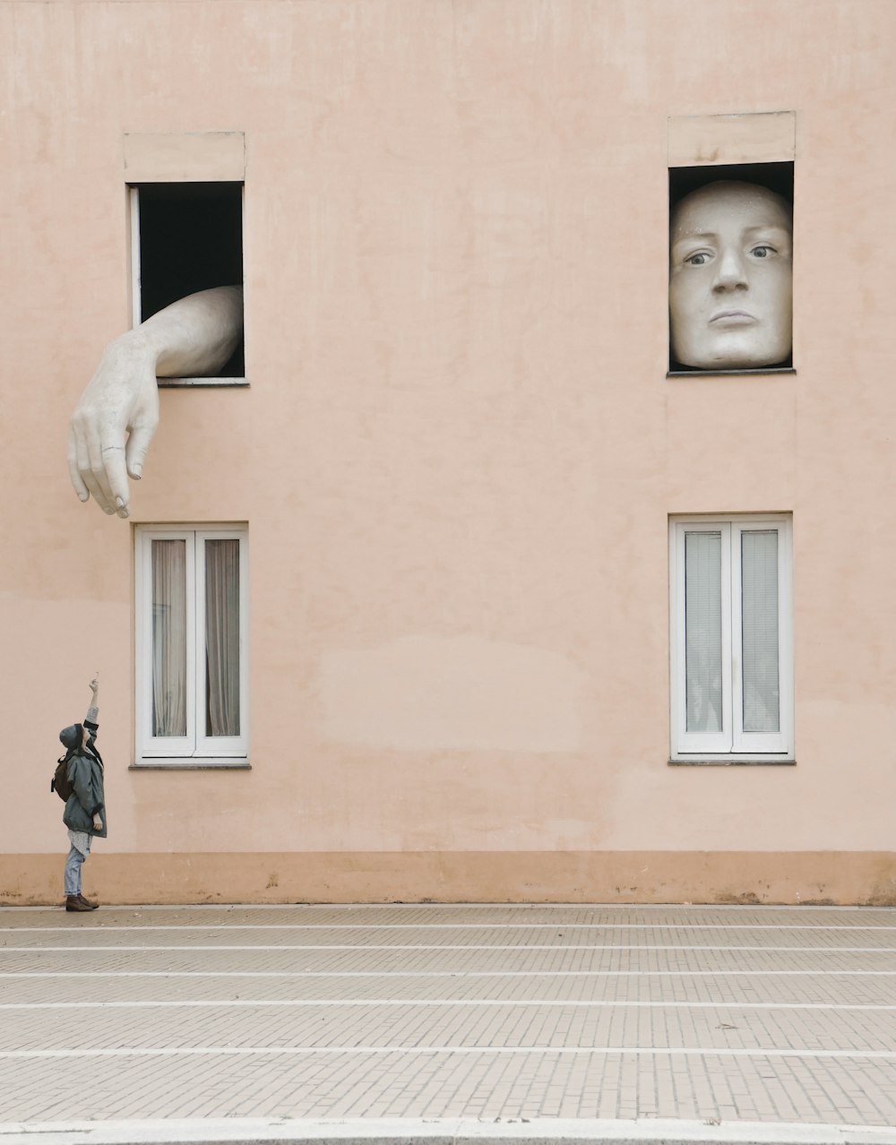 person raising hand under the window