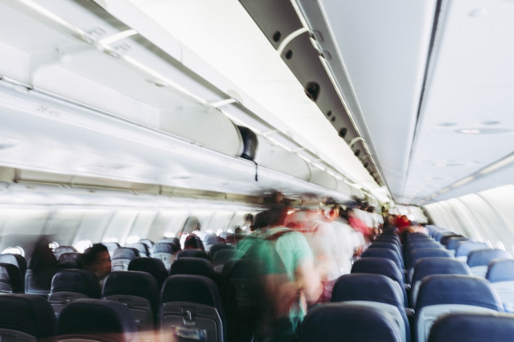 Photographie en accéléré de personnes marchant dans le couloir de l’avion