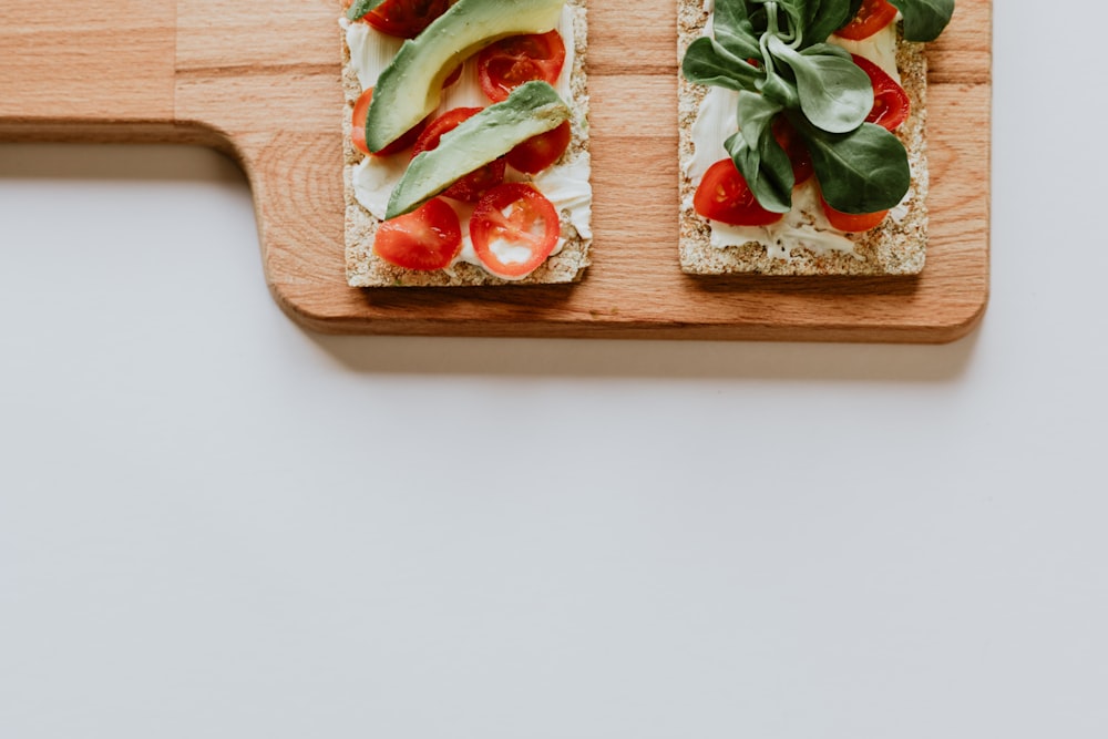 Avocado und Tomaten auf dem Tablett in Scheiben schneiden