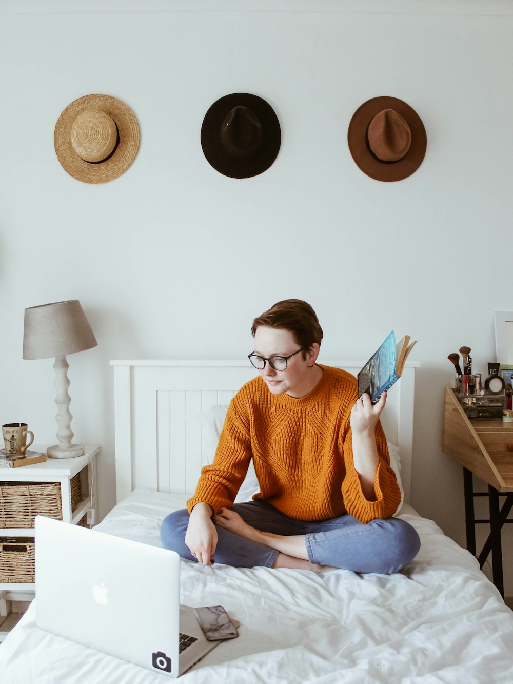 woman sitting on bed facing laptop