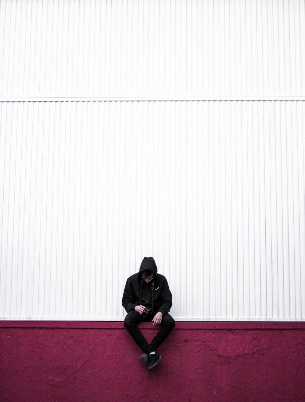 man sitting on purple wall