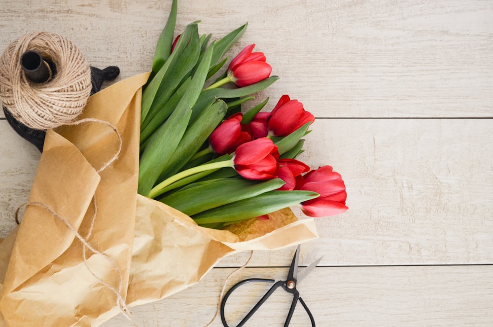 red tulip flowers bouquet on brown wooden pallet