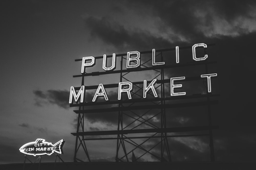 fotografía en escala de grises de la señalización de neón del mercado público