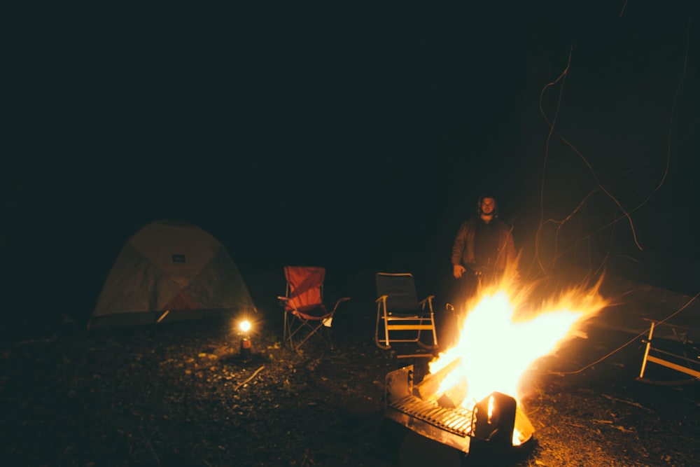 Mann in der Nähe eines Lagerfeuers während der Nacht