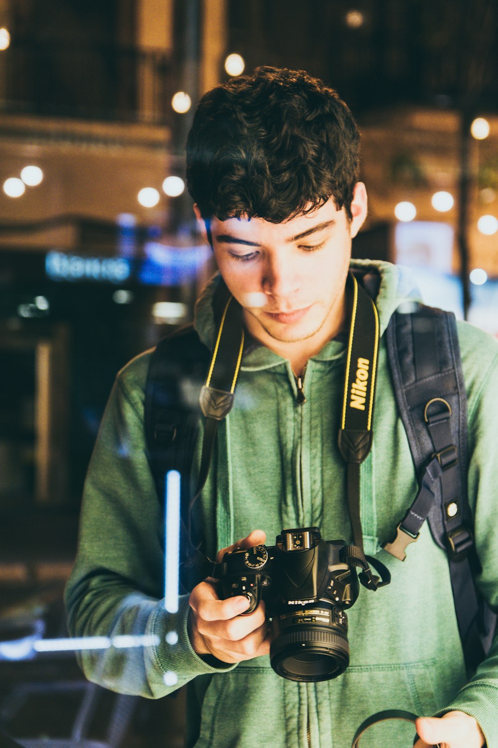 fotografía bokeh de hombre mirando fijamente en la cámara DSLR