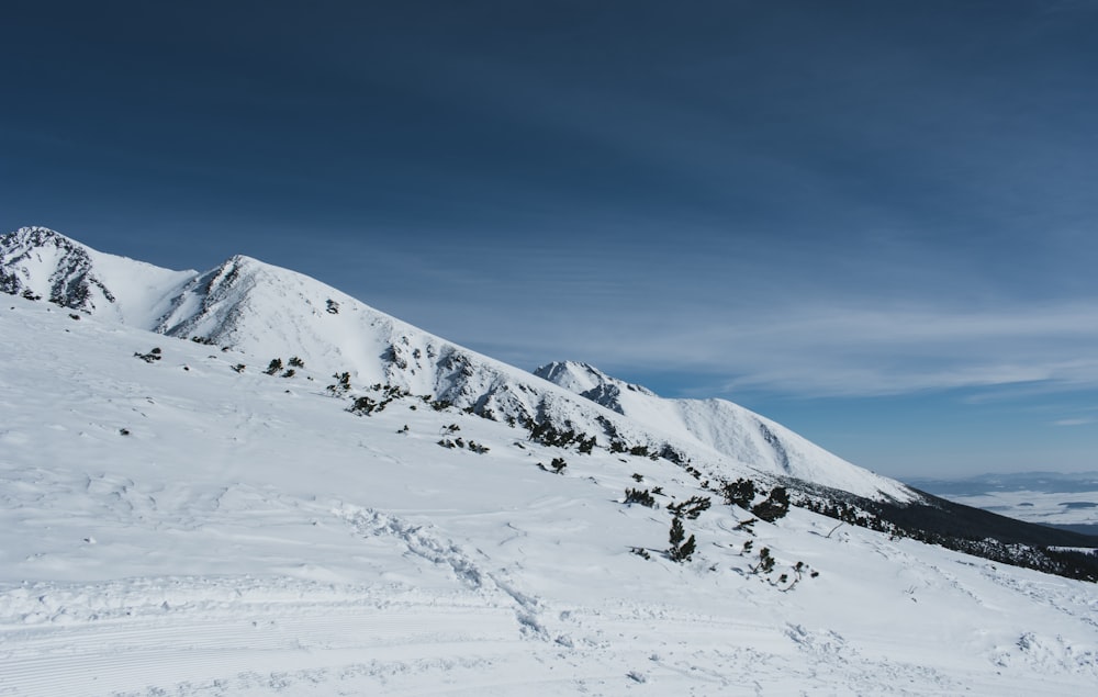 glacier hill under white and blue cloudy skies