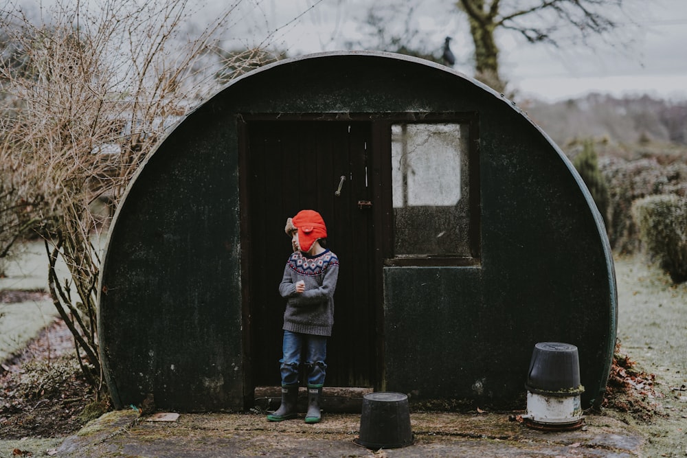 person standing behind green dome shed