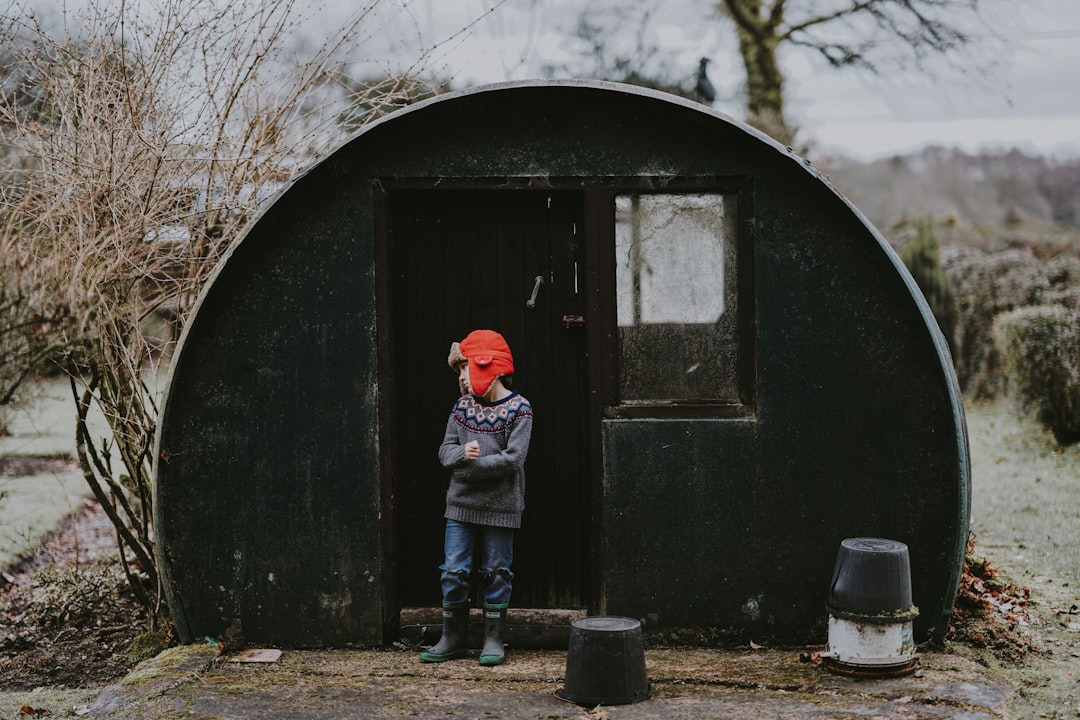 person standing behind green dome shed