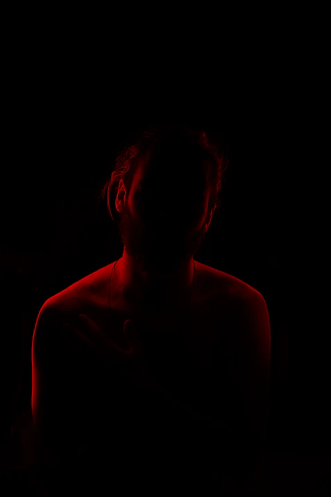 a woman in a dark room with a red light
