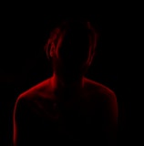 a woman in a dark room with a red light