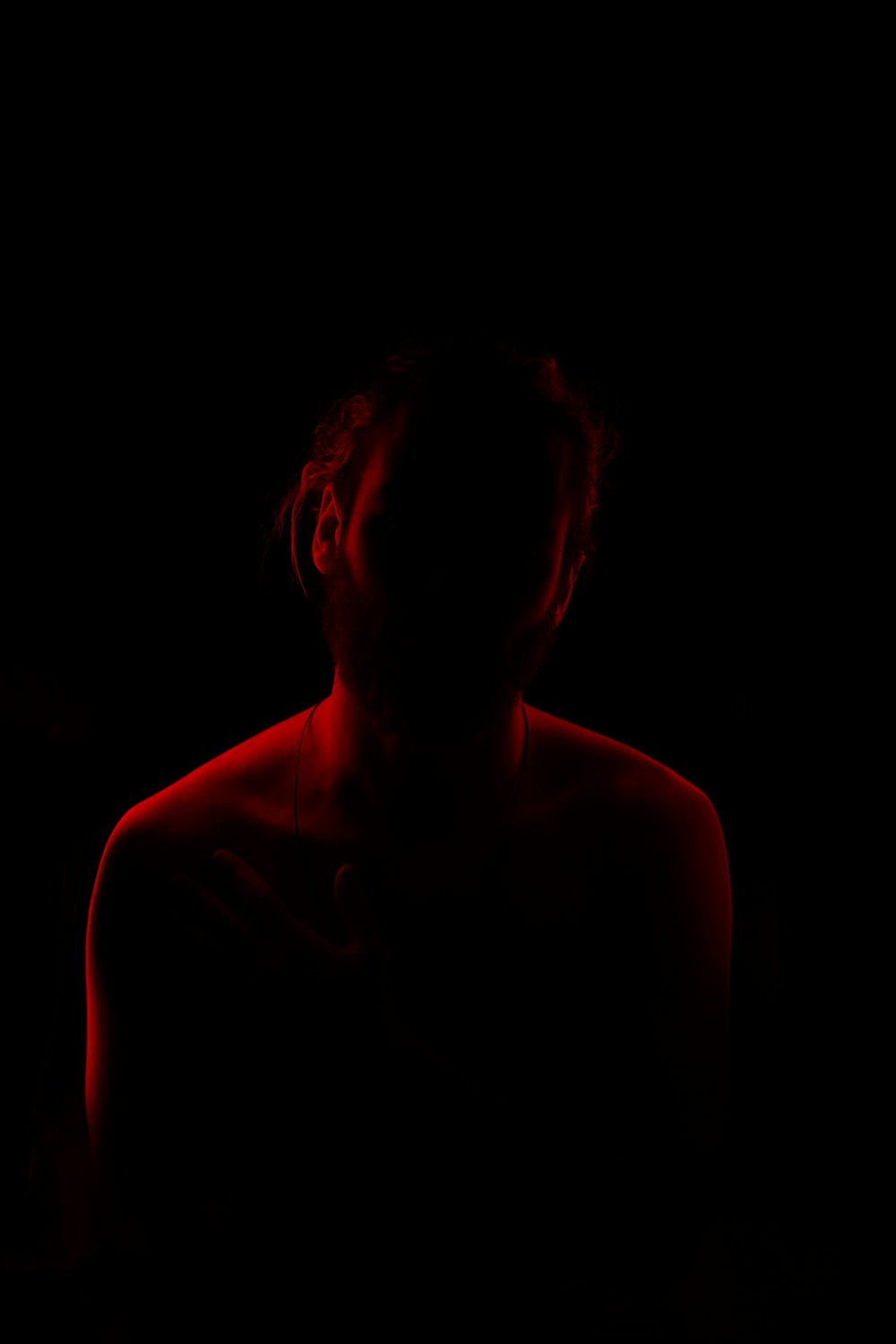 a woman in a dark room with a red light