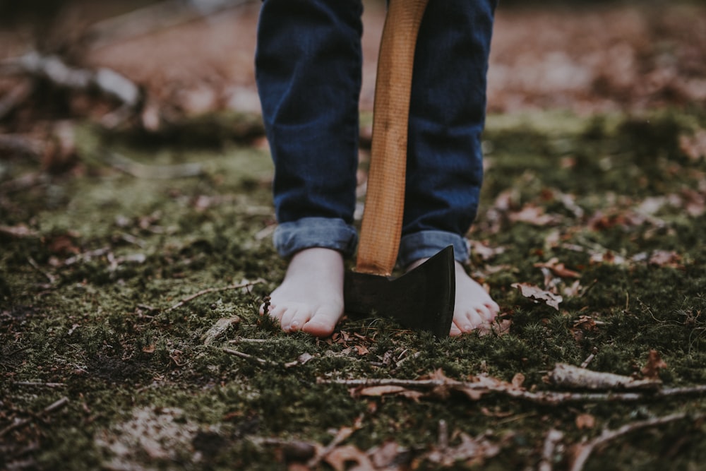 person standing on ground with axe