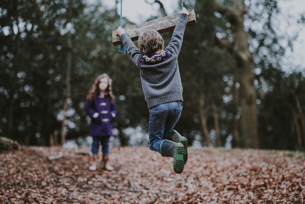 boy holding on swing bench