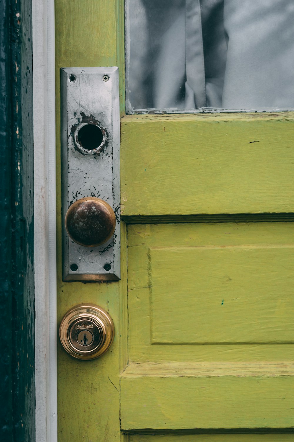 brown door knob in green wooden door