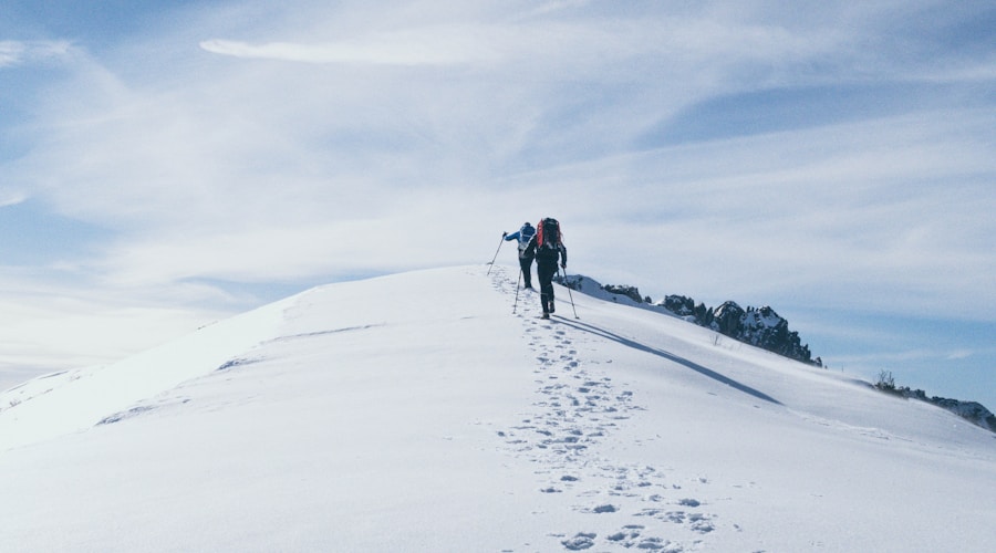two person climbing on mountain covered snow