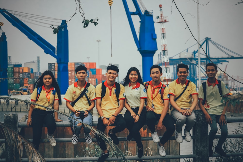 group of people sitting on metal railings