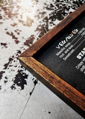 A stylish leather menu cover displayed on a wooden table.