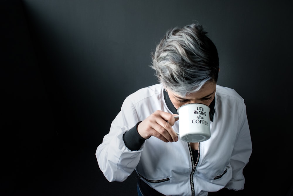 woman holding mug in drinking gesture