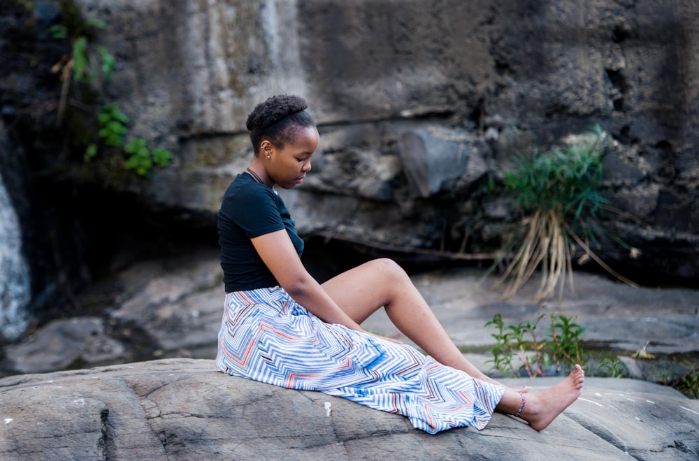 woman sitting on rock near cliff during daytime