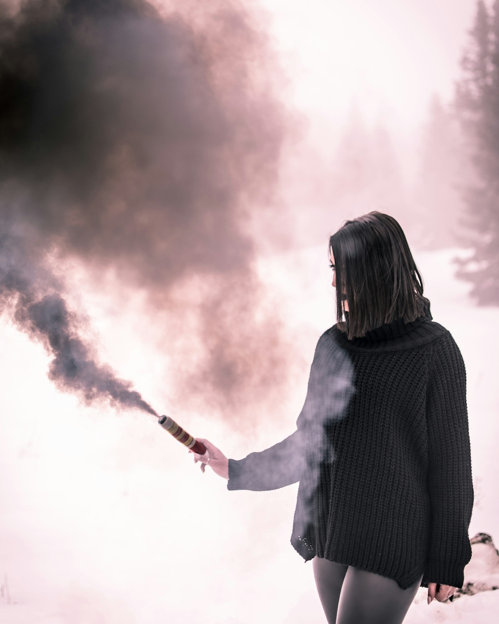 Donna in camicia a maniche lunghe in maglia nera utilizzando il bastone nero con fumo