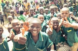 A group of kids wearing deep forest green protective pads, smiling confidently.