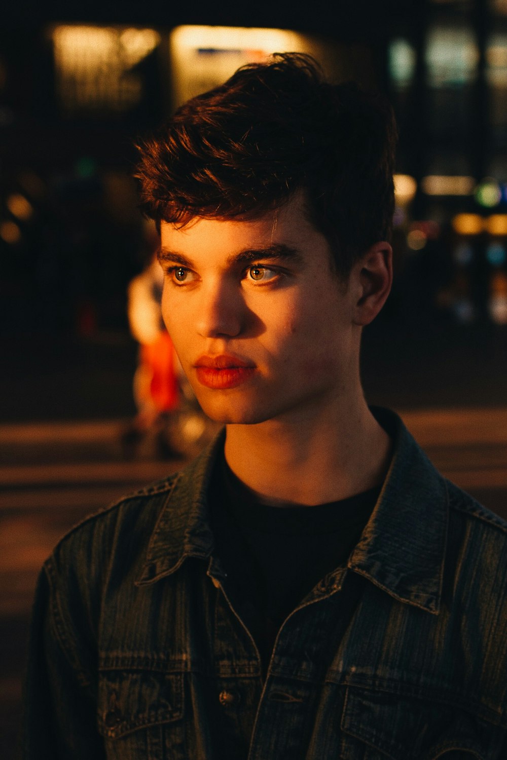 photo bokeh photo of man wearing gray denim jacket