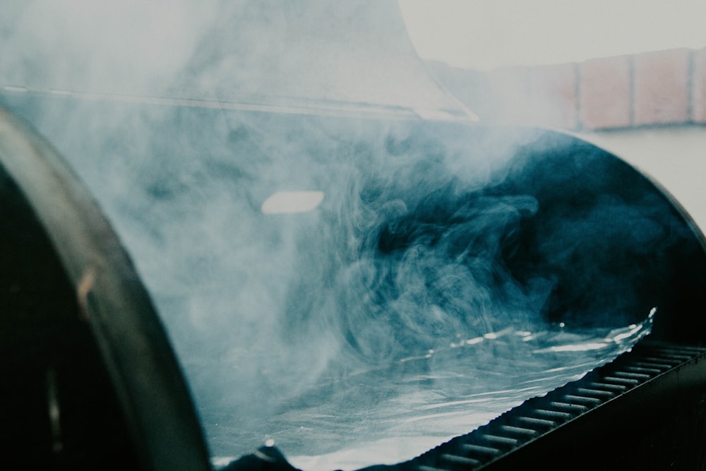 smoke coming out of an outdoor grill on a sunny day