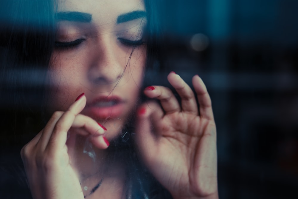 woman showing both hands with red manicures