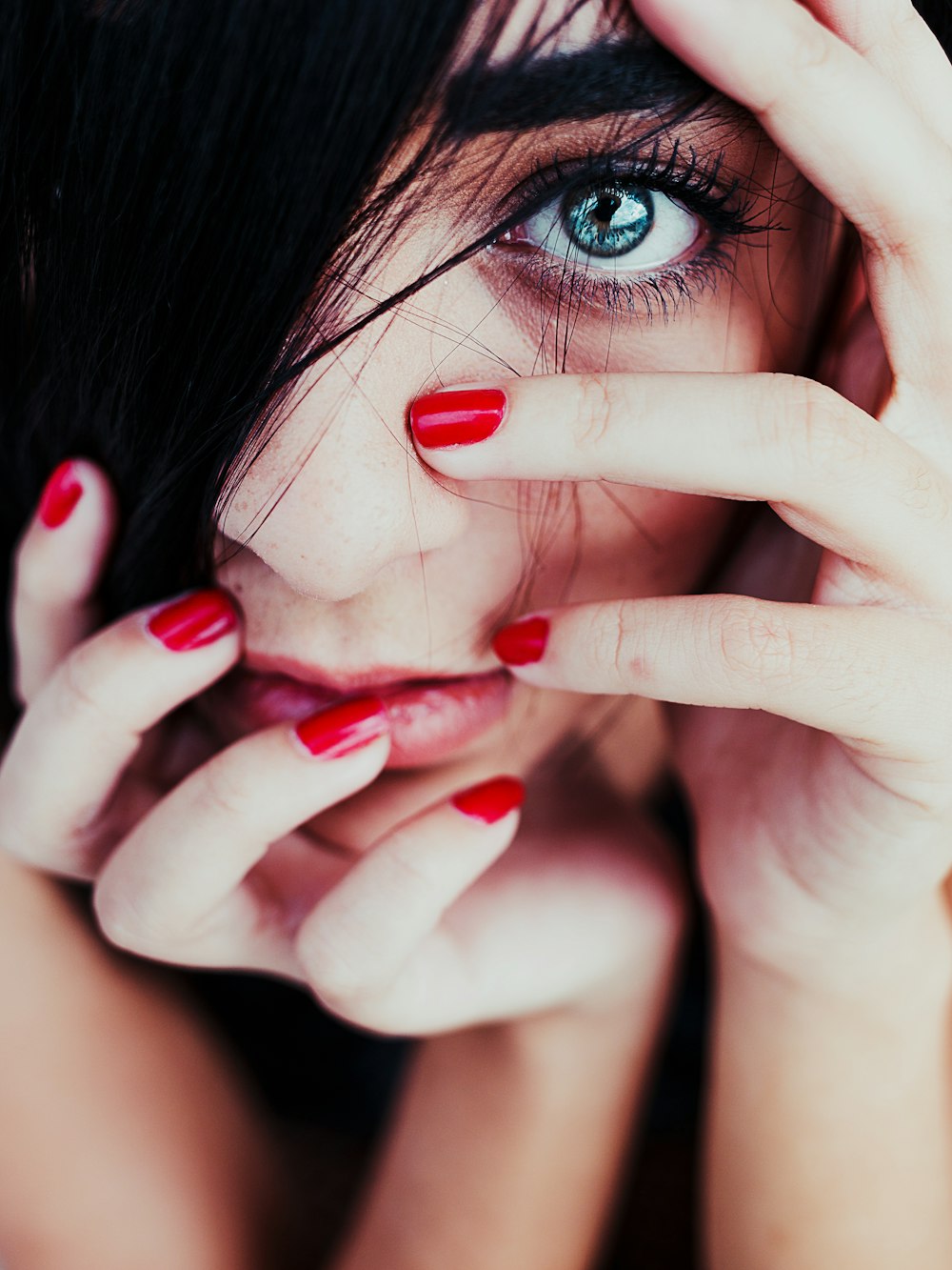 a close up of a person with red nail polish