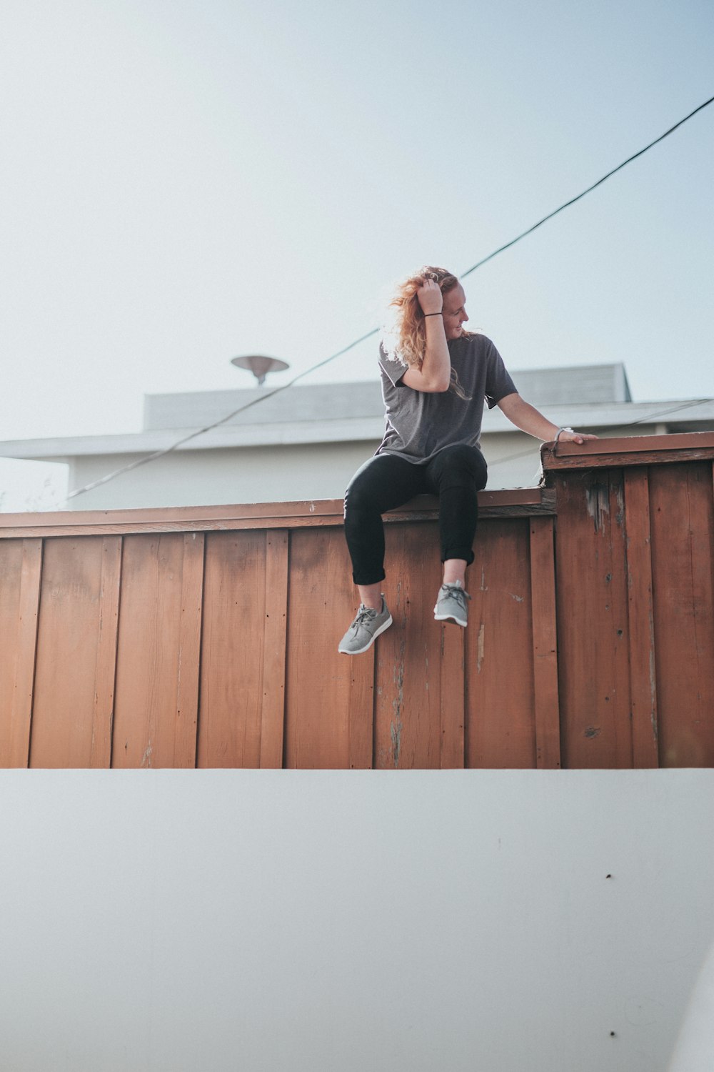 man sitting on fence during daytime