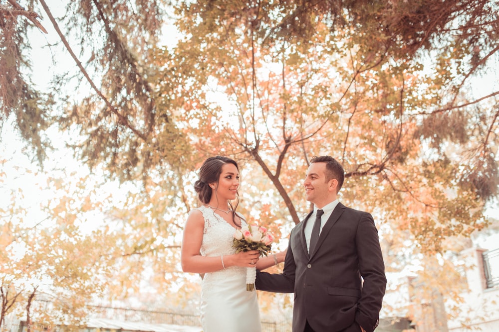 man and woman face each other near tree