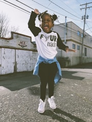 girl stand near Ace storefront under cloudy sky during daytime