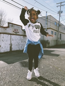 girl stand near Ace storefront under cloudy sky during daytime