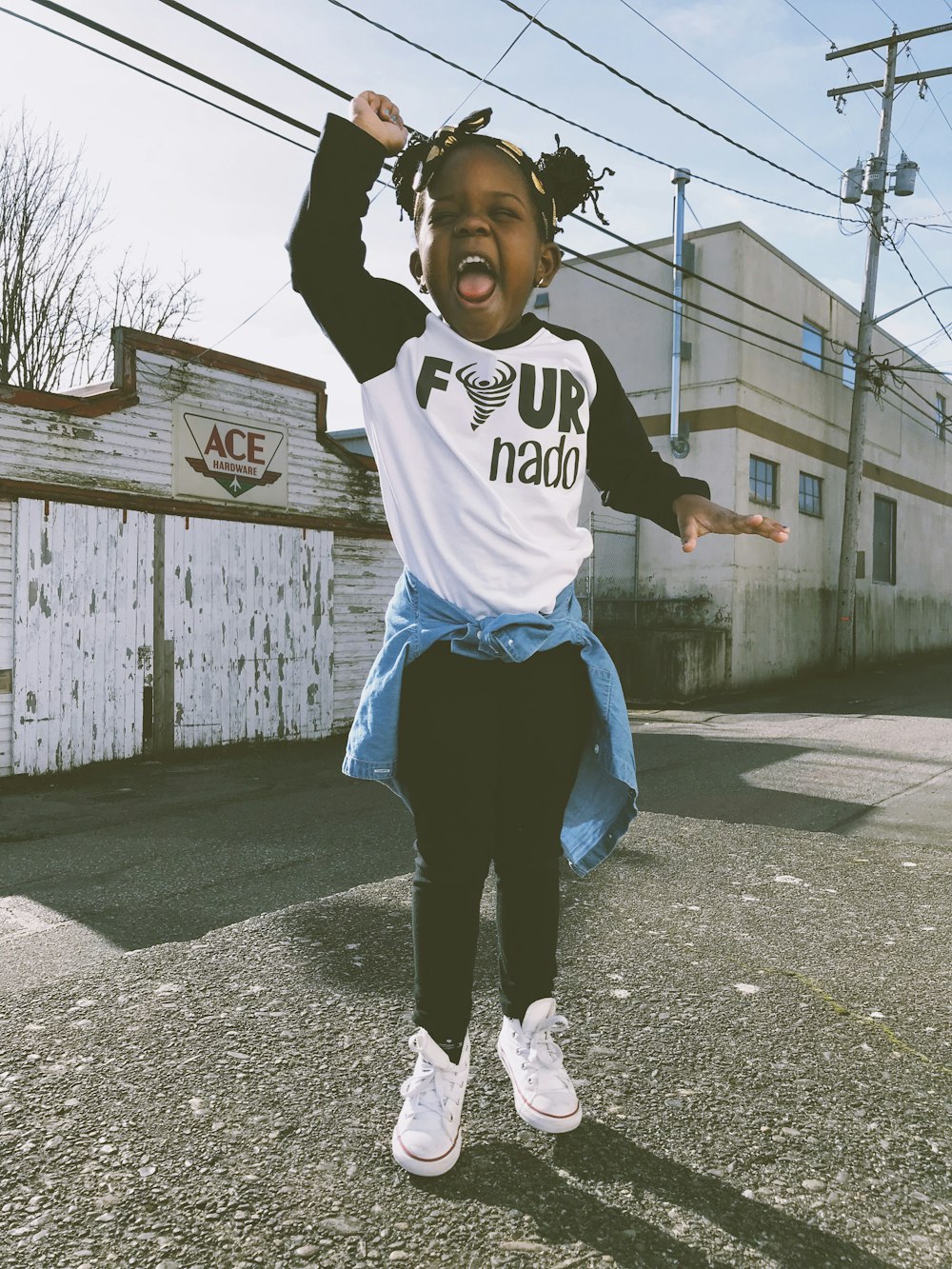 girl stand near Ace storefront under cloudy sky during daytime