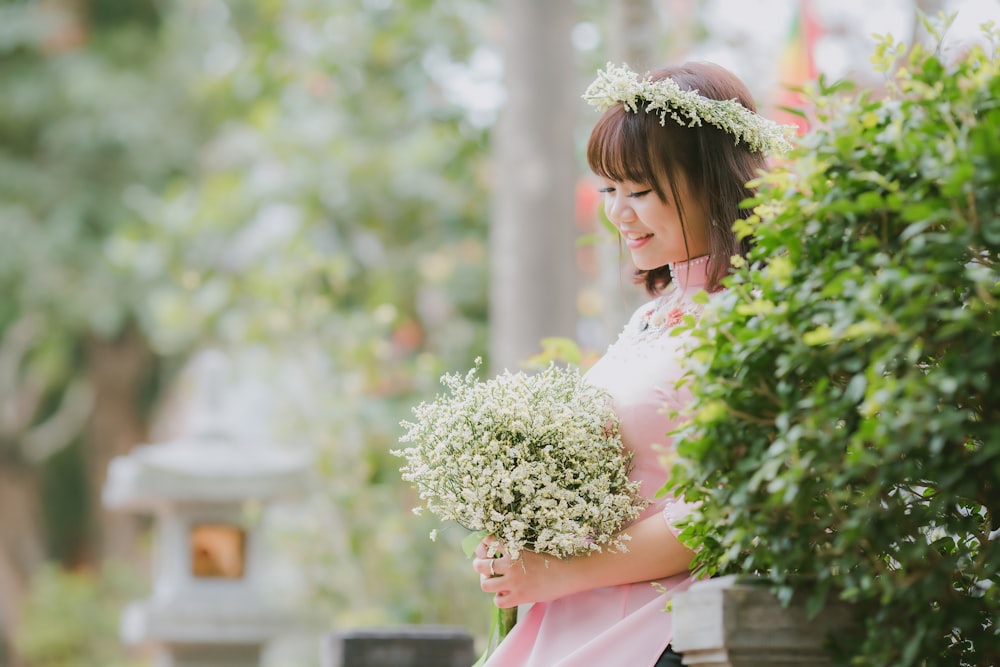 selective focus photography of woman holding bouquet of flowers