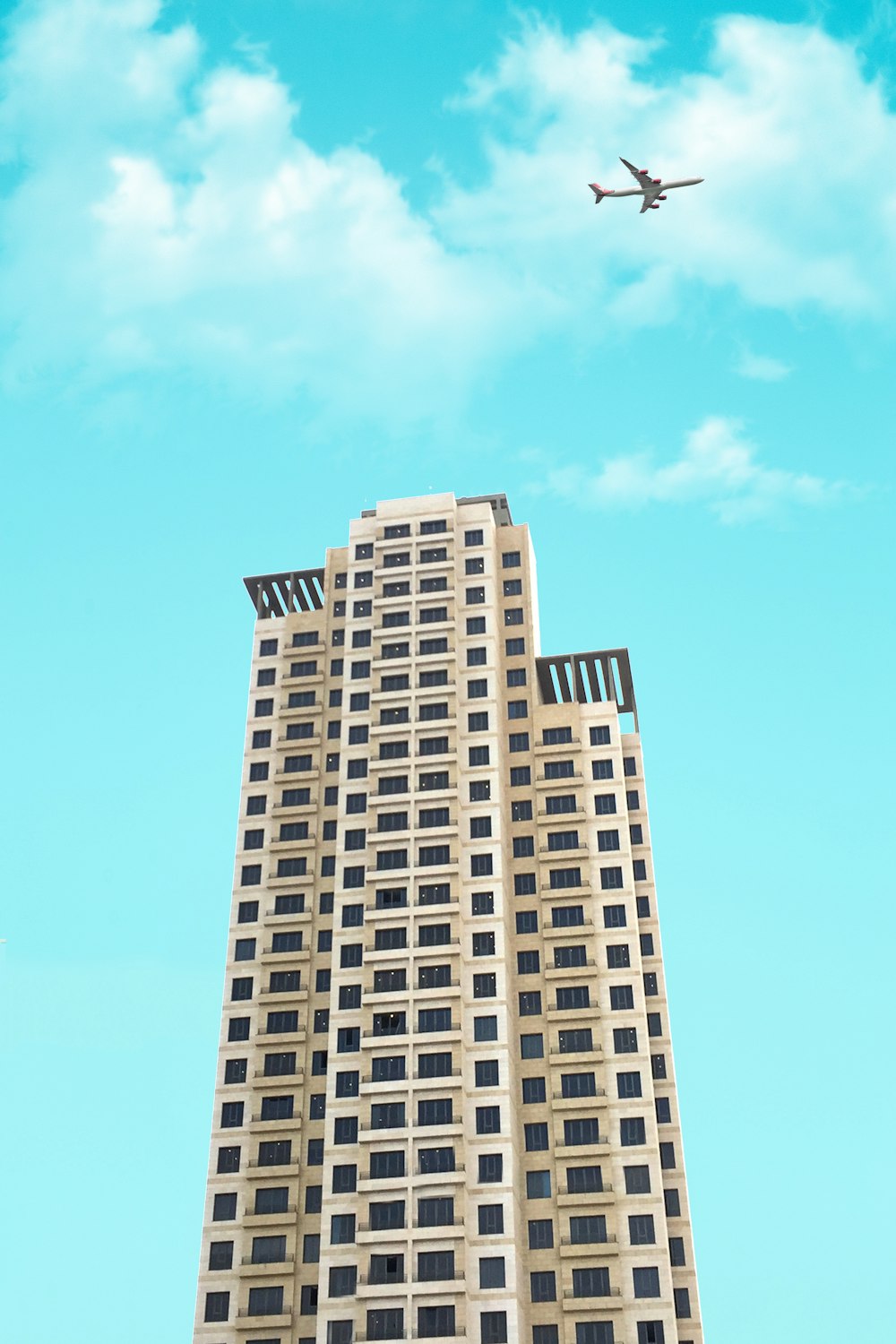 photo of white high-rise building under blue and white sky